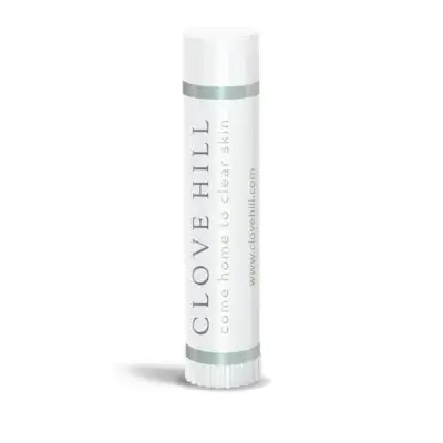 White lip balm tube standing upright with teal bands and vertical text 'CLOVE HILL' and 'come home to clear skin' on a clean white background.